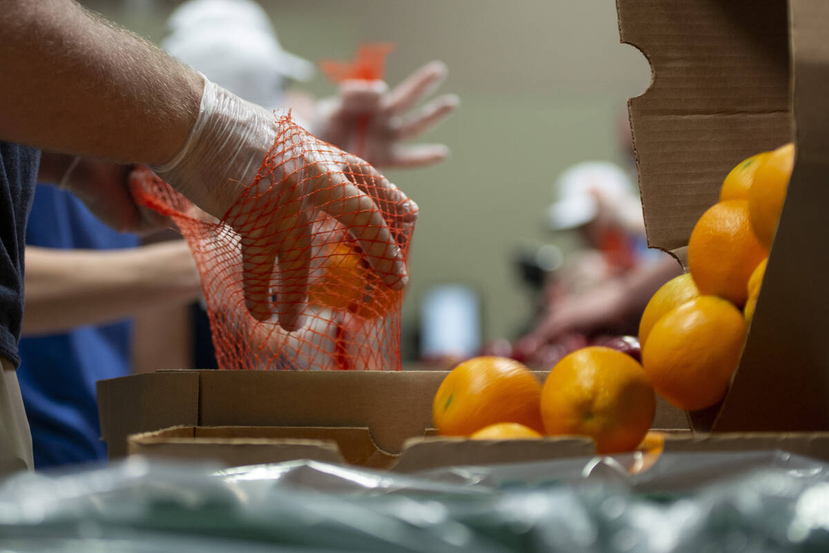 Volunteers help pack bags of fruit at the Three Square Food Bank. (Las Vegas Review-Journal file)