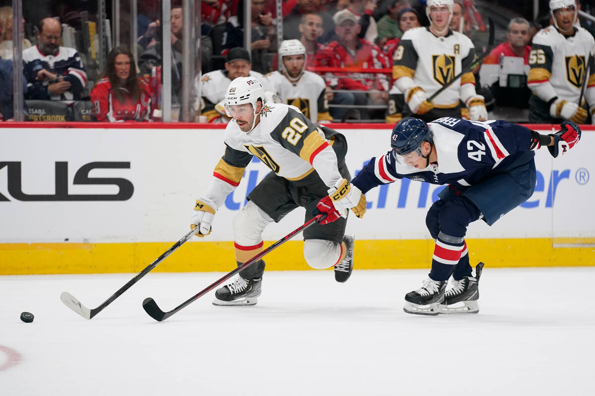 Vegas Golden Knights center Chandler Stephenson, left, moves the puck past Washington Capitals ...