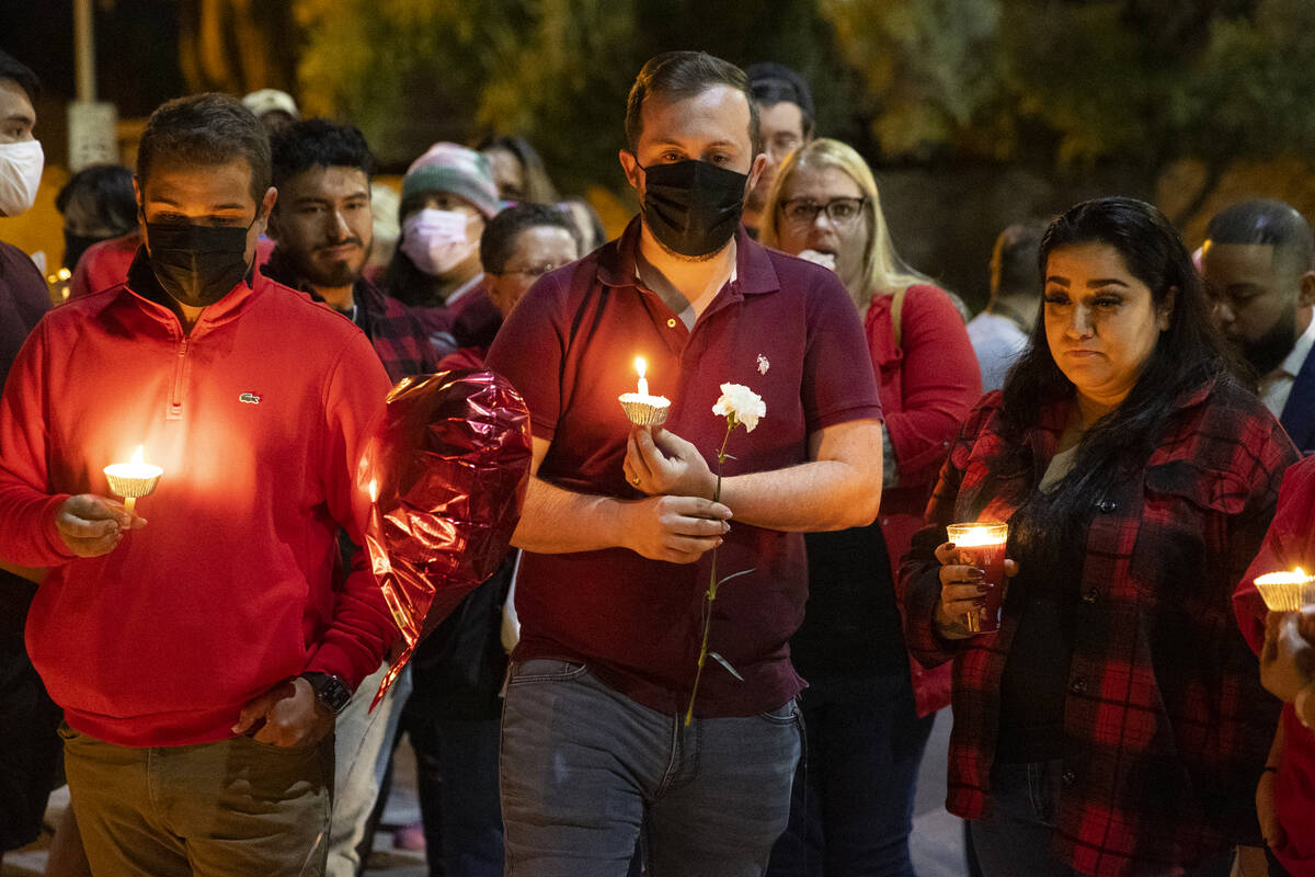Heitor Gomes, from left, Patrick Lafleur and Rachel Gattis, attend a vigil for their co-worker ...