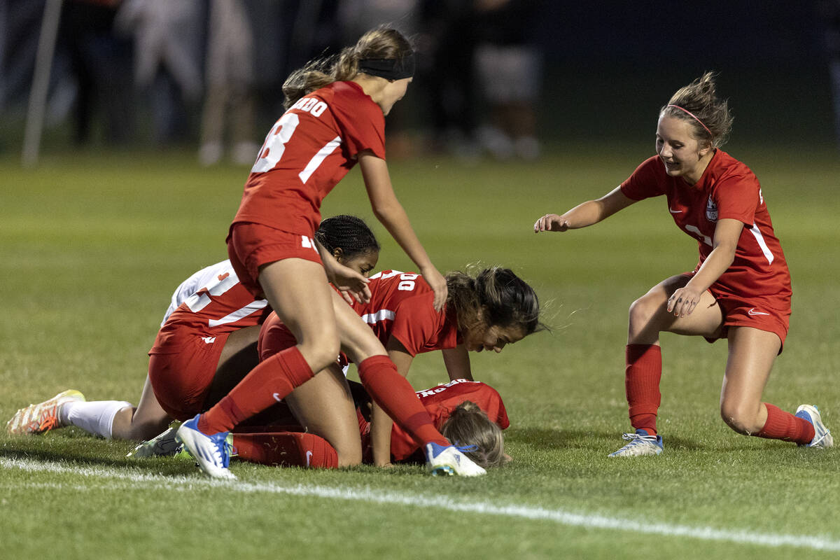 Coronado players tackle their Tia Garr after she scored the game-winning goal against Desert Oa ...