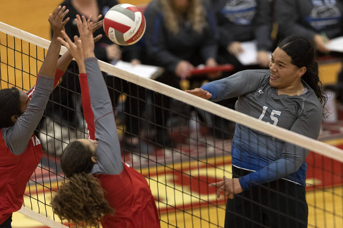 Basic’s Daryn Faumui (15) spikes to Arbor View’s Cameron Reese, left, and Willow ...