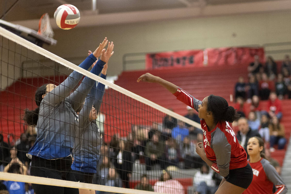 Arbor View’s Cameron Reese (12) spikes past Basic’s Daryn Faumui, left, and Marti ...