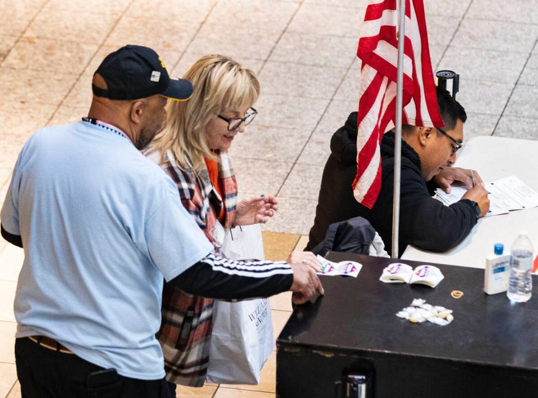 A Voter, who declined to give her name, picks "I Voted" sticker after placing her bal ...