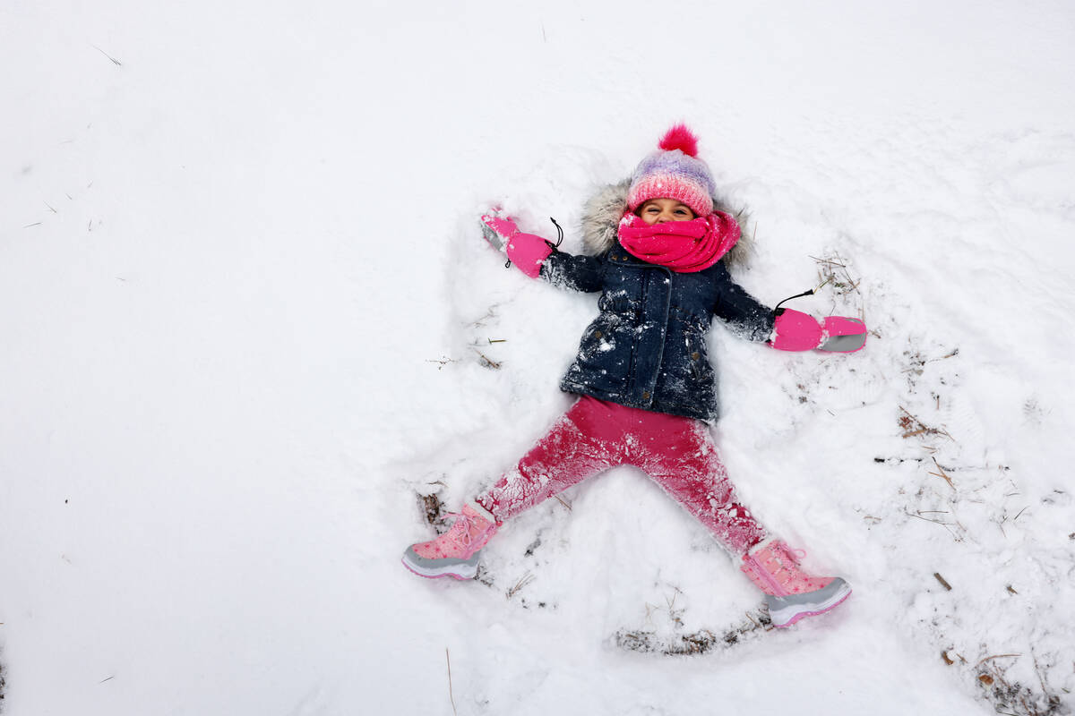Angel Frias-Irizarry, 3, of Las Vegas makes a snow angel in freshly fallen snow, in Upper Lee M ...