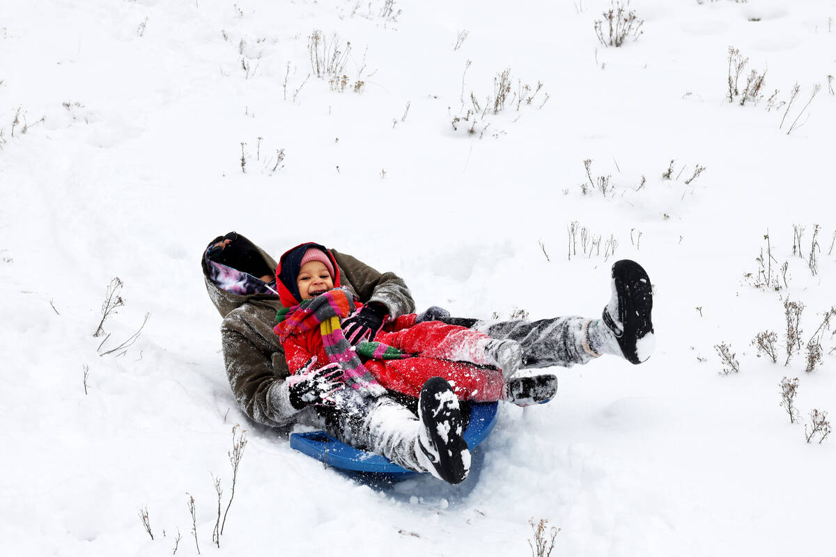 Greyson Murdock, 3, and his mom Logan Murdock sled in freshly fallen snow, in Upper Lee Meadows ...