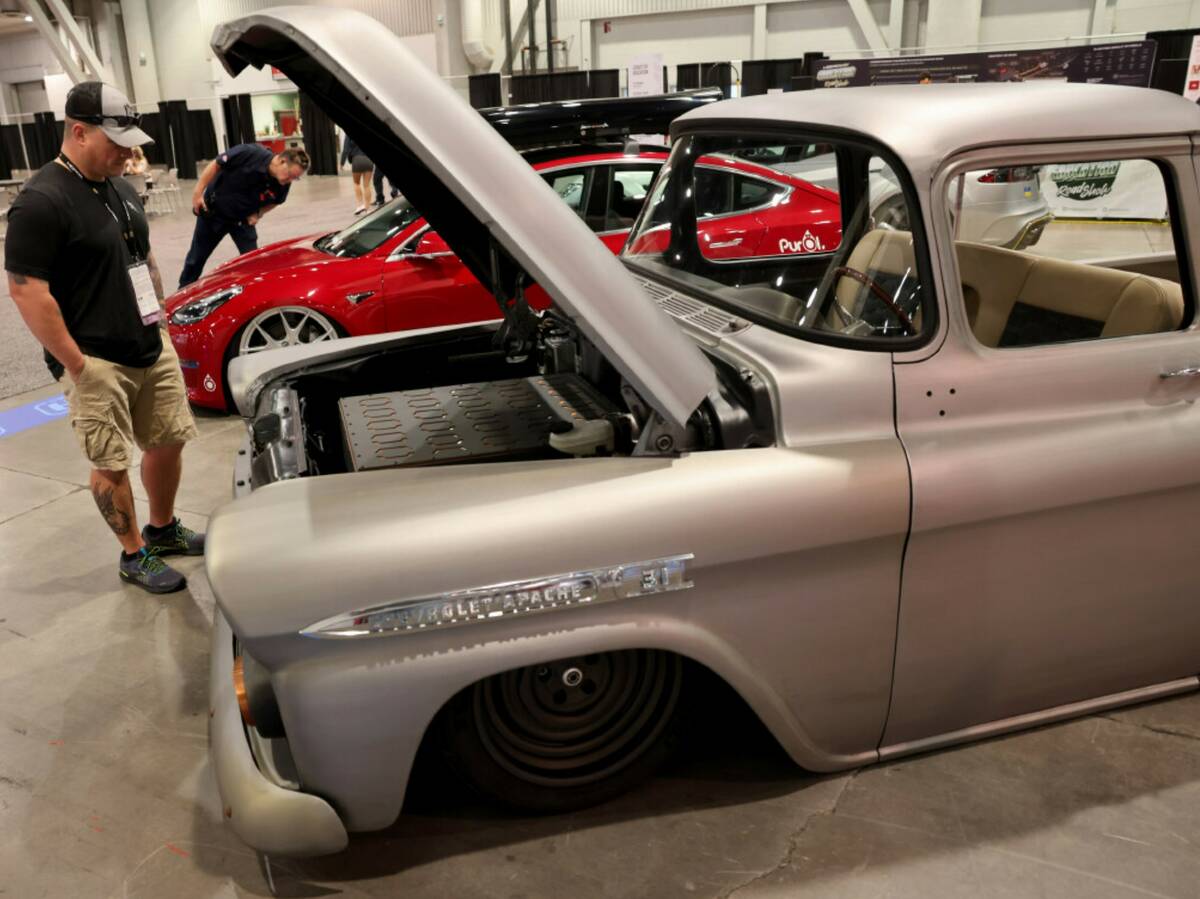 Eric Bellefeuille of St. Paul, Minn. checks out a fully electric 1958 Chevy Apache in the SEMA ...