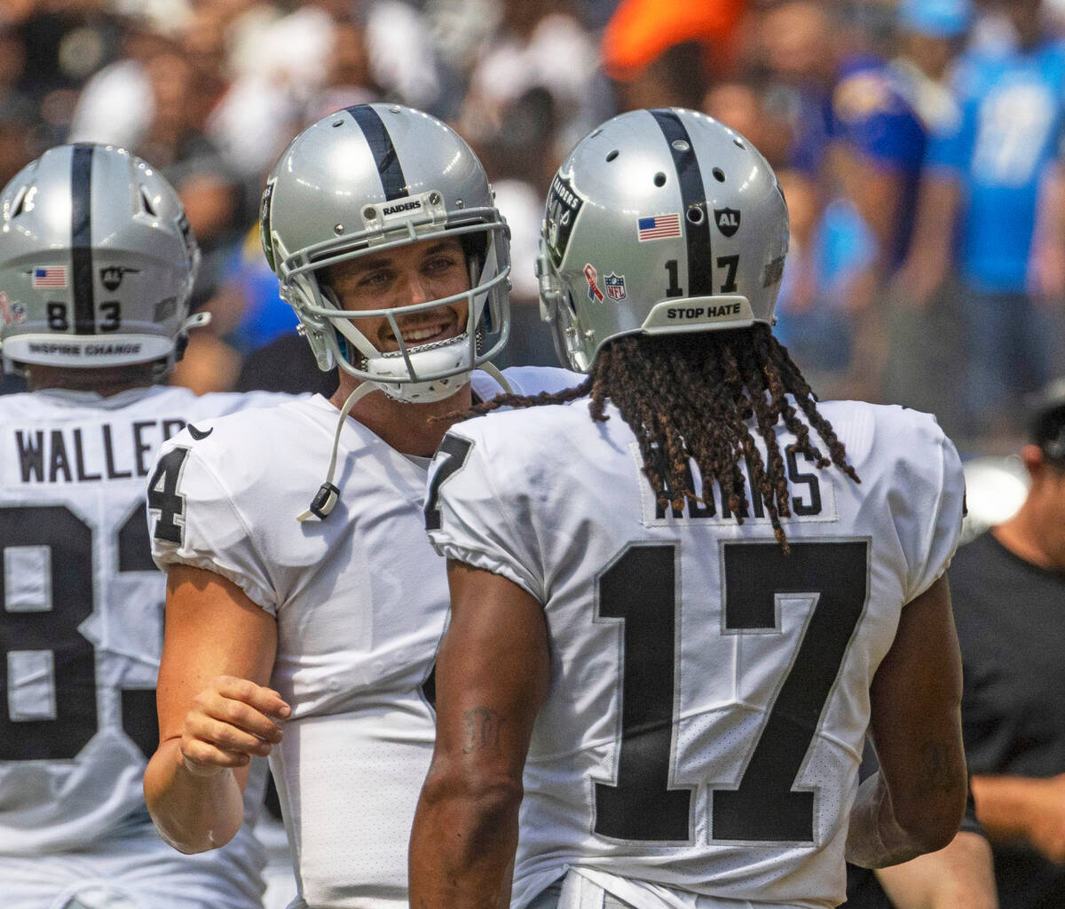 Raiders quarterback Derek Carr (4) and Raiders wide receiver Davante Adams (17) meet on the sid ...