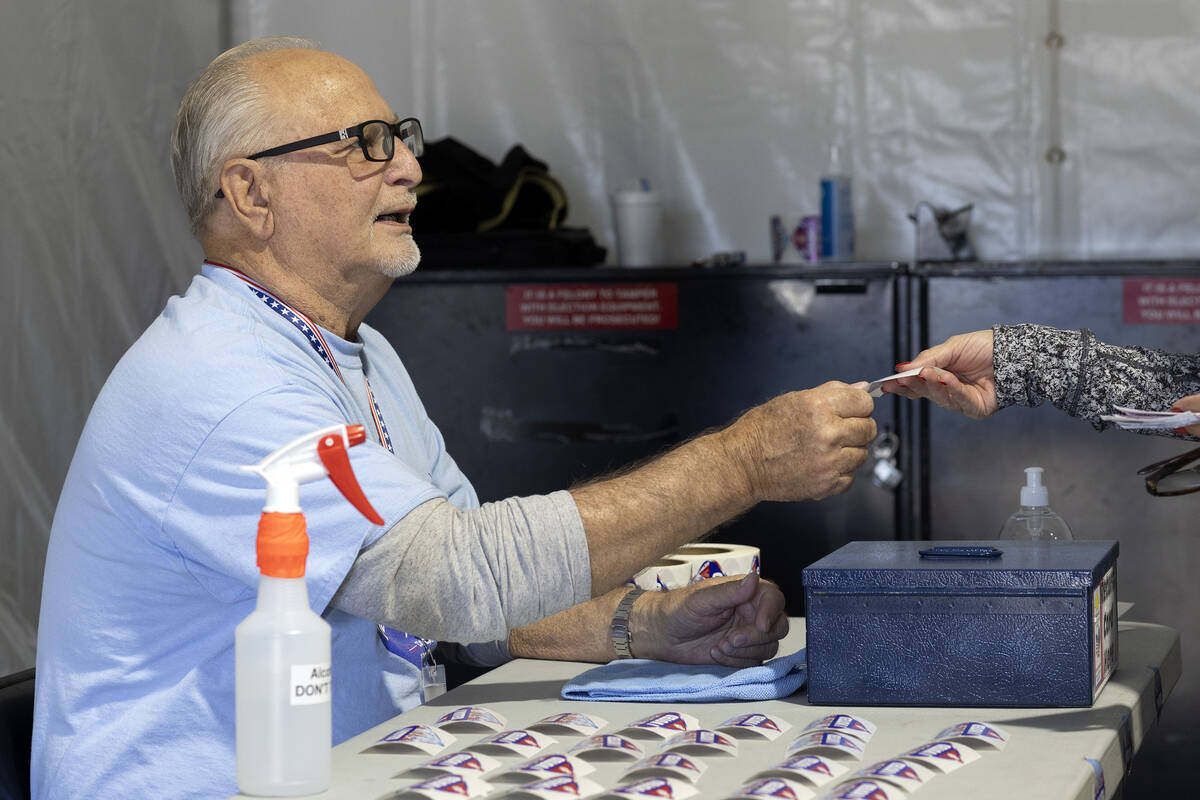 Volunteer Dennis Kepper hands out I Voted stickers on the last day of early voting, Friday, Nov ...