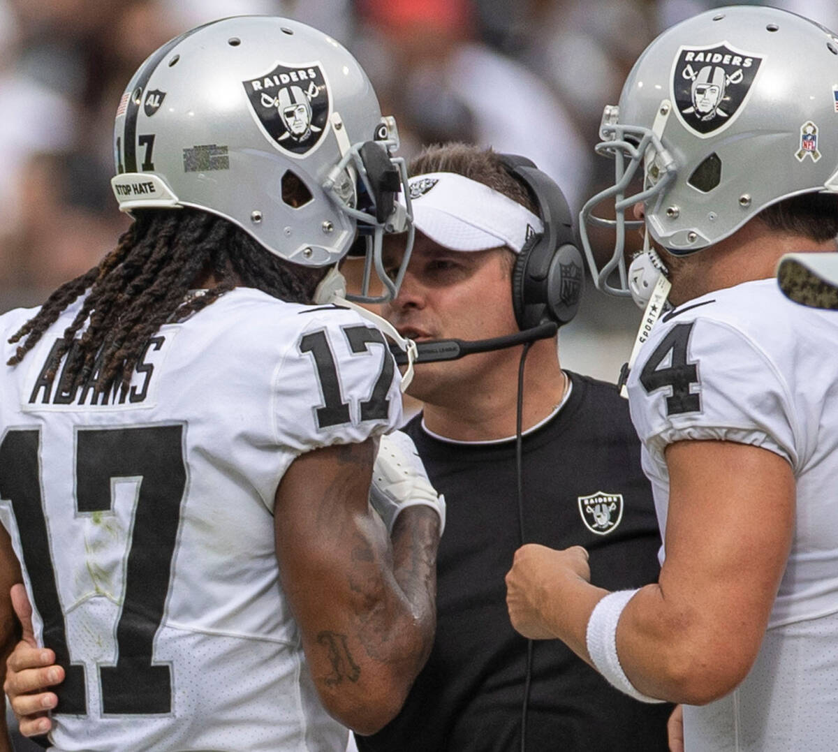 Raiders head coach Josh McDaniels speaks to wide receiver Davante Adams (17) on the sideline as ...