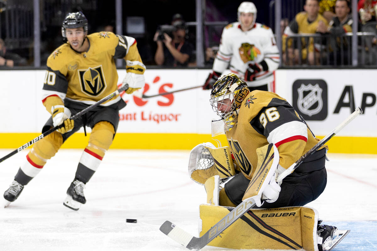 Golden Knights goaltender Logan Thompson (36) makes a save while Golden Knights center Nicolas ...