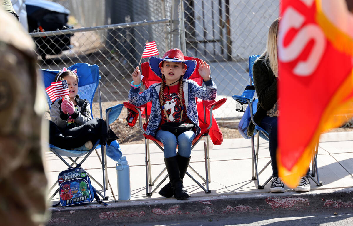 lily Tirres, 5, and her sister Lucy, 8, watch the Veterans Day parade on Fourth Street in downt ...