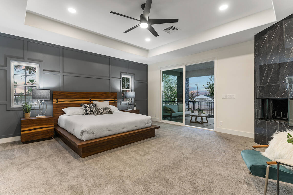 In the primary bedroom, a dark gray architectural accent wall behind the bed added texture to t ...