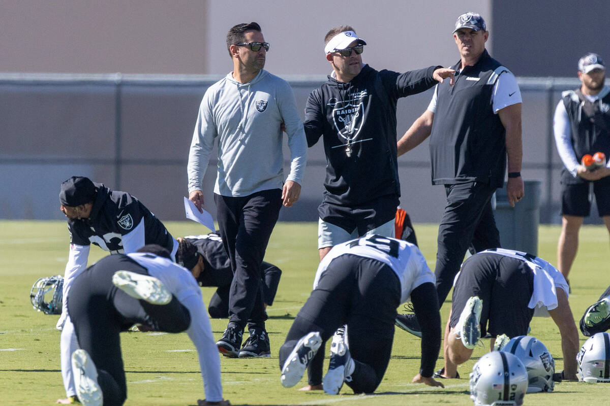 Raiders general manager Dave Ziegler, left, speaks with head coach Josh McDaniels during practi ...