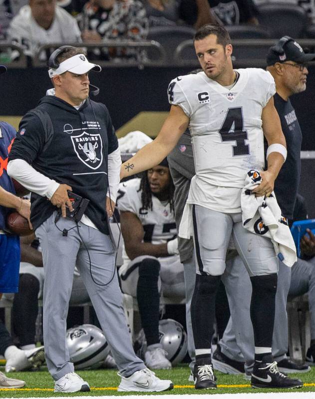 Raiders quarterback Derek Carr (4) tries to speak to head coach Josh McDaniels during the secon ...