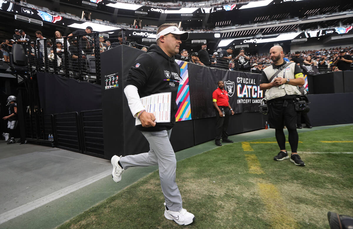 Raiders head coach Josh McDaniels runs onto the field before an NFL game against the Houston Te ...