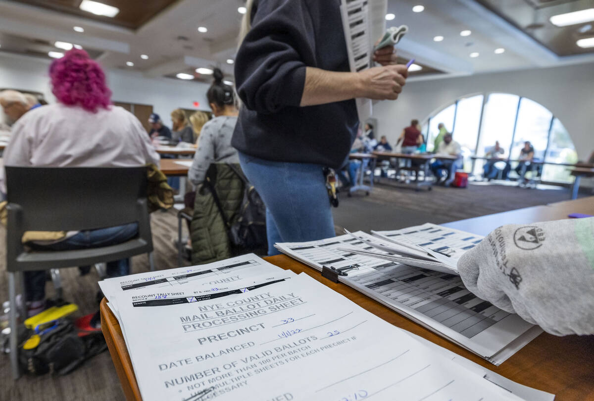 Stacks of counted ballots are separated as volunteers resume hand counting ballots in Nye Count ...