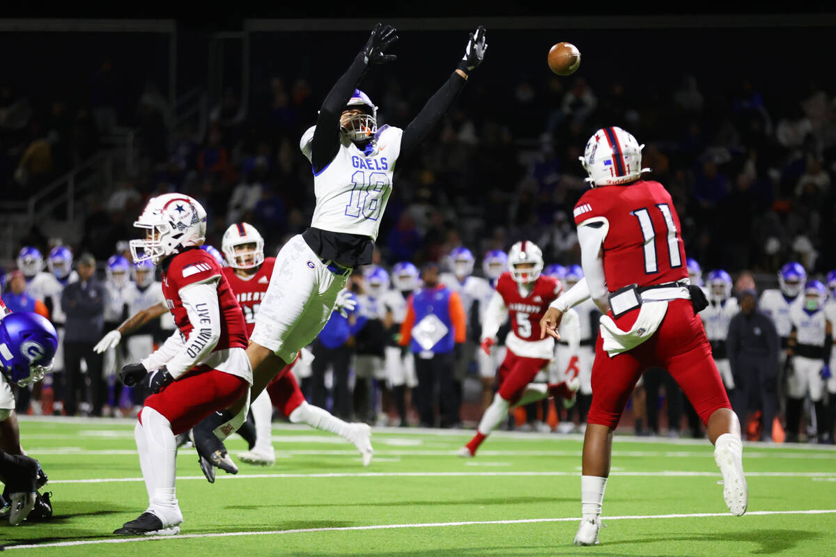 Liberty's Tyrese Smith (11) throws a pass under pressure from Bishop Gorman's Jonah Leaea (18) ...