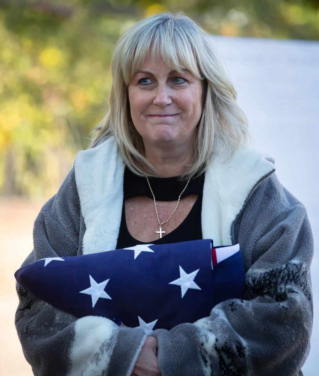 Colleen Herbst holds a folded flag during a ceremony in honor of the Kiel family remains being ...