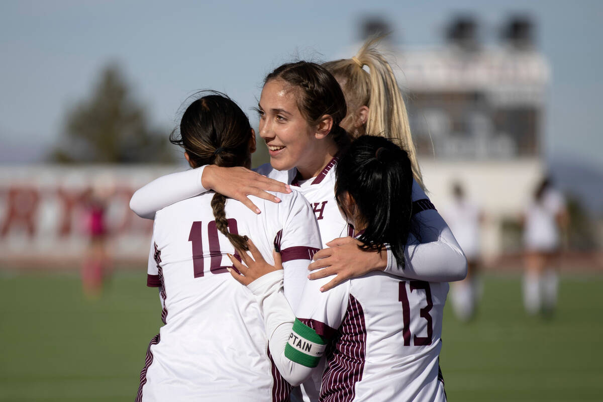 Faith Lutheran’s Madeline Mariani, center, hugs teammates Andrea Leyva (10) and Mia Coe ...