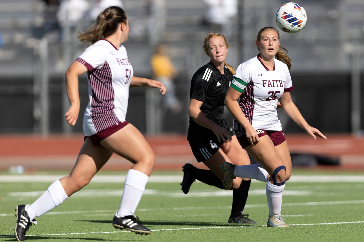 Faith Lutheran’s Taylor Folk (26) anticipates a pass while Lana Linares, left, runs for ...