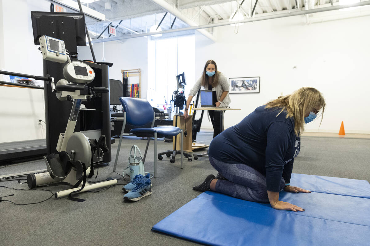 Gwen Vaughn, right, diagnosed with Parkinson's disease, works with her physical therapist Kelly ...