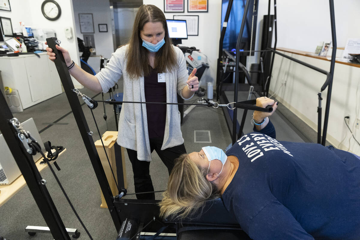 Gwen Vaughn, right, diagnosed with Parkinson's disease, works with her physical therapist Kelly ...