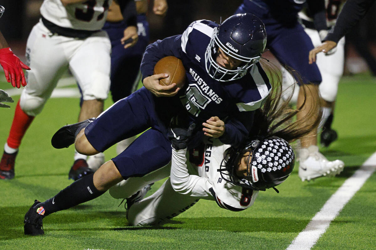 Shadow Ridge’s Gage Crnkovic (6) is tackled by Las Vegas’ Kawika Lopez, bottom, during the ...