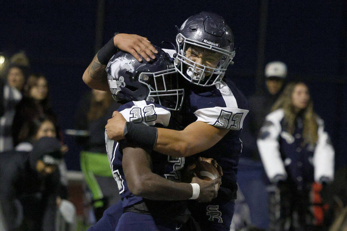 Shadow Ridge’s Jon Wilson (32) celebrates his touchdown with his teammate Blaise Soares ...