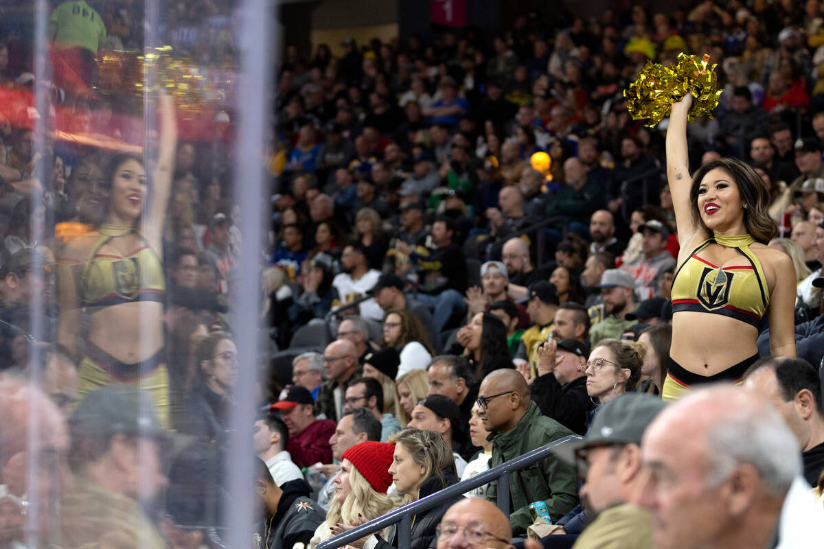 A Vegas Golden Knights cheerleader, right, pumps up the crowd during the second period of an NH ...