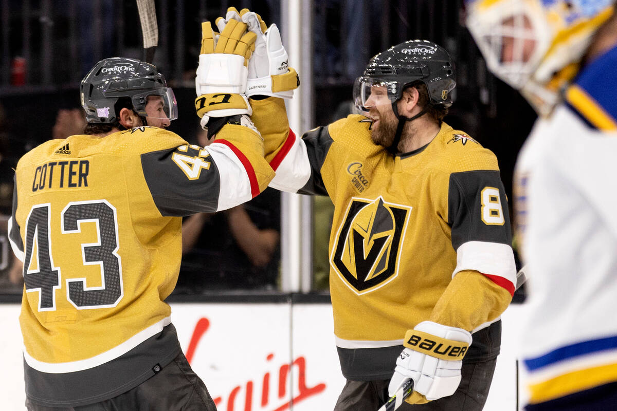 Vegas Golden Knights center Paul Cotter (43) slaps hands with center Phil Kessel (8) after Kess ...