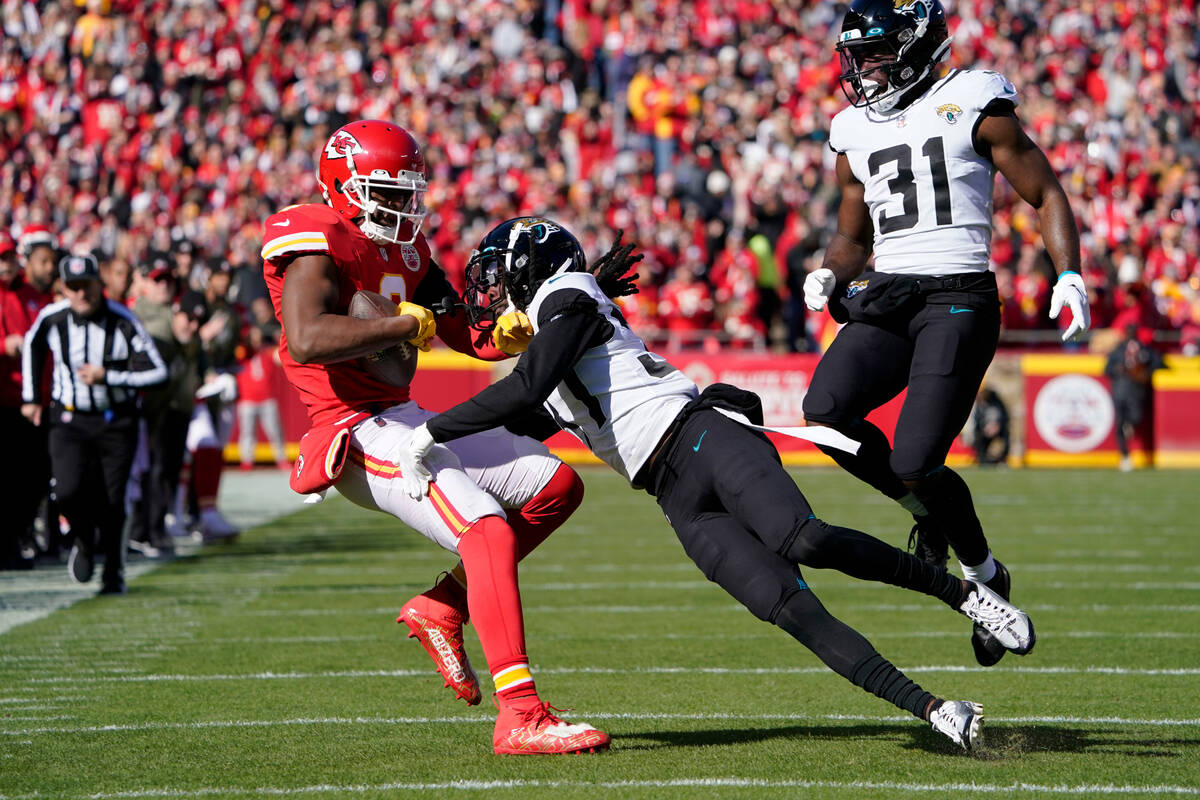 Kansas City Chiefs wide receiver JuJu Smith-Schuster, left, catches a pass as Jacksonville Jagu ...