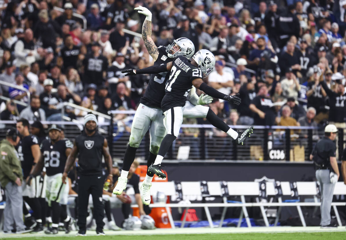 Raiders defensive end Maxx Crosby (98) celebrates with cornerback Amik Robertson (21) after sa ...