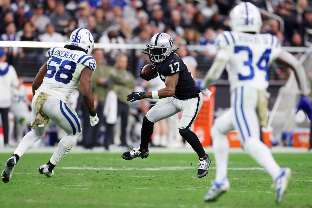 Raiders wide receiver Davante Adams (17) runs the ball after a catch as Indianapolis Colts line ...