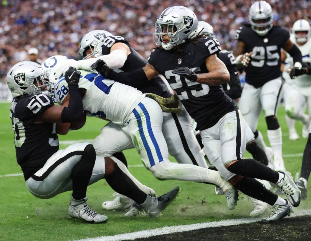 Raiders linebacker Jayon Brown (50) and defensive end Maxx Crosby (98) tackle Indianapolis Colt ...