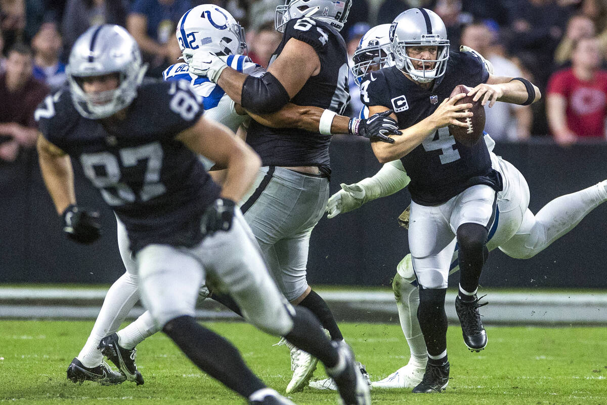 Raiders quarterback Derek Carr (4)nis grabbed in the pocked by Indianapolis Colts defensive end ...