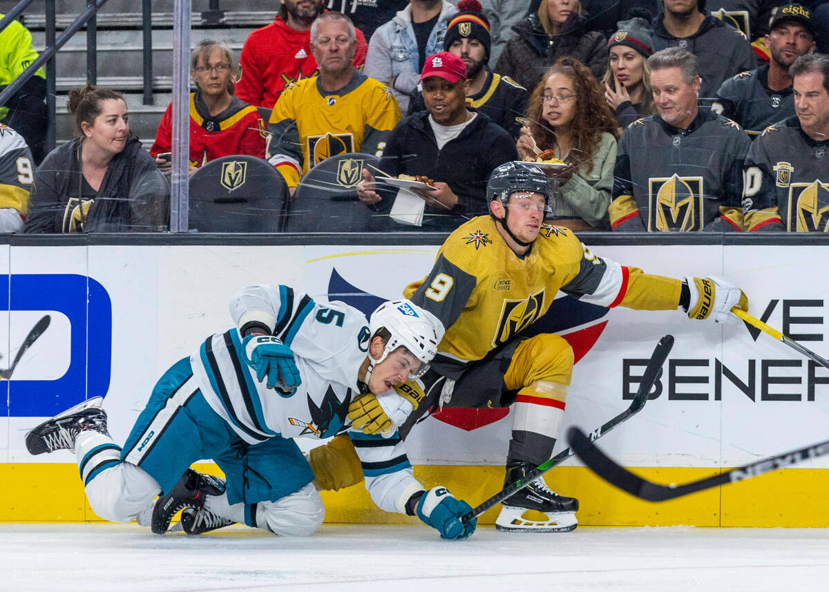 Golden Knights center Jack Eichel (9) tangles with San Jose Sharks defenseman Matt Benning (5) ...