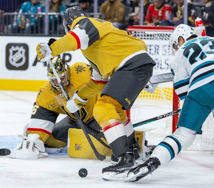 Golden Knights goaltender Logan Thompson (36) eyes a puck with teammate defenseman Zach Whitecl ...