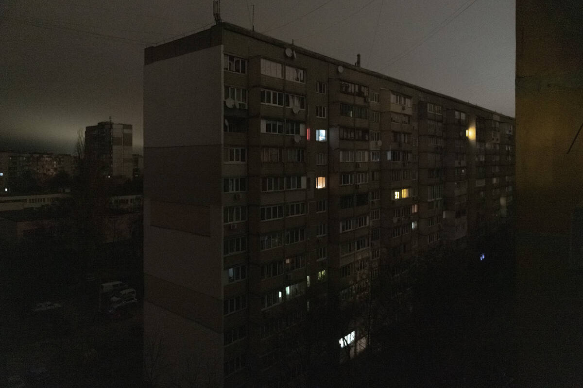 Windows of an apartment building are illuminated during a blackout in central Kyiv, Ukraine, Mo ...