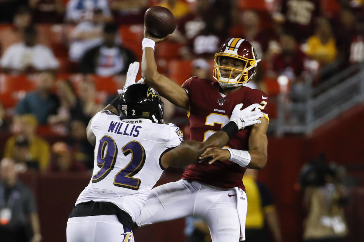 Washington Redskins quarterback Jalan McClendon (2) gets the pass off as he is hit by Baltimore ...