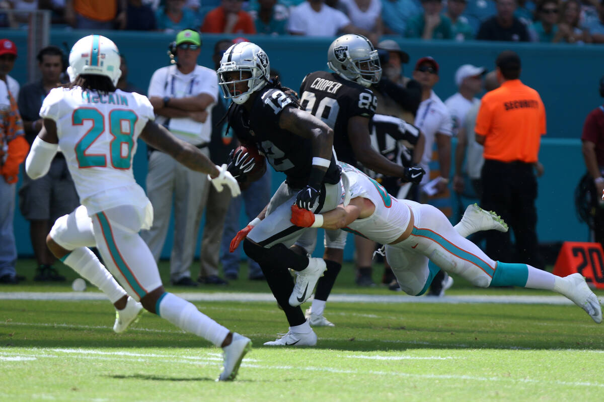 Oakland Raiders wide receiver Martavis Bryant (12) tries to break a tackle from linebacker Miam ...