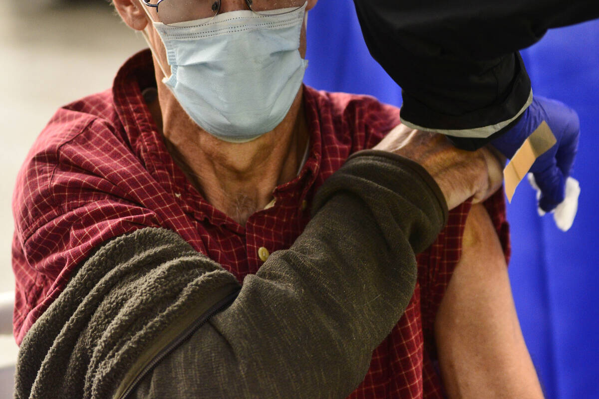 A man receives a flu shot in Brattleboro, Vt., on Tuesday, Oct. 26, 2021. Health authorities ar ...