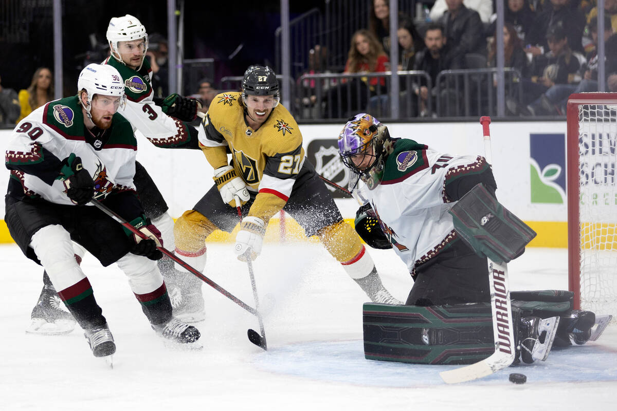 Coyotes goaltender Karel Vejmelka (70) saves a shot on goal by Golden Knights defenseman Shea T ...