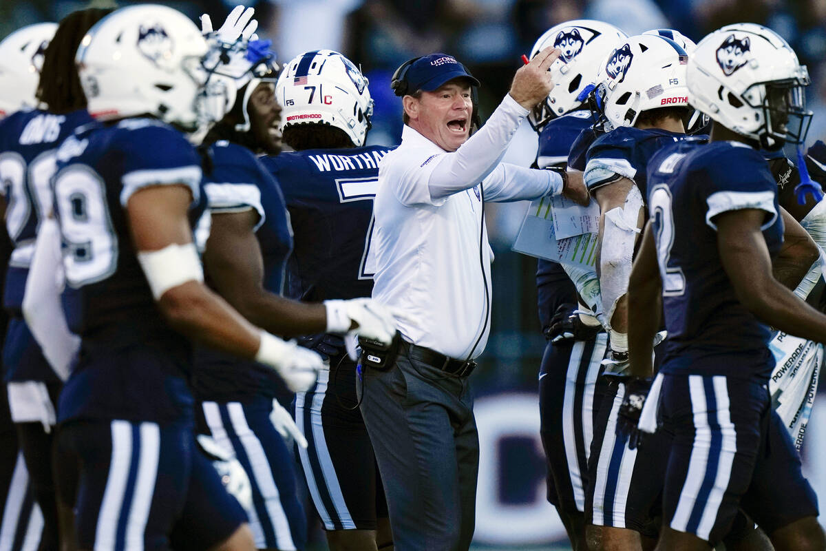 Connecticut head coach Jim Mora singles to players during the second half of an NCAA college fo ...