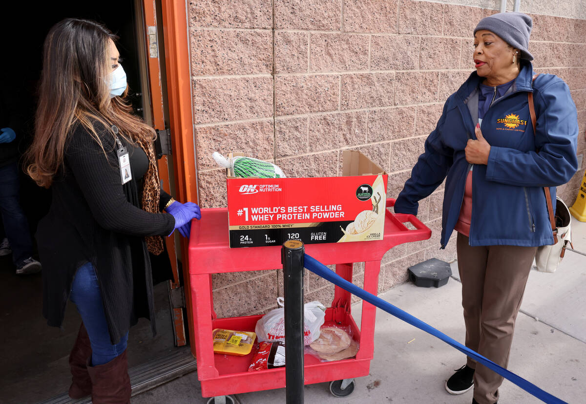 Maria Ochoa gives a turkey and other food to Patricia Sanders of Las Vegas at the Hands of Hope ...