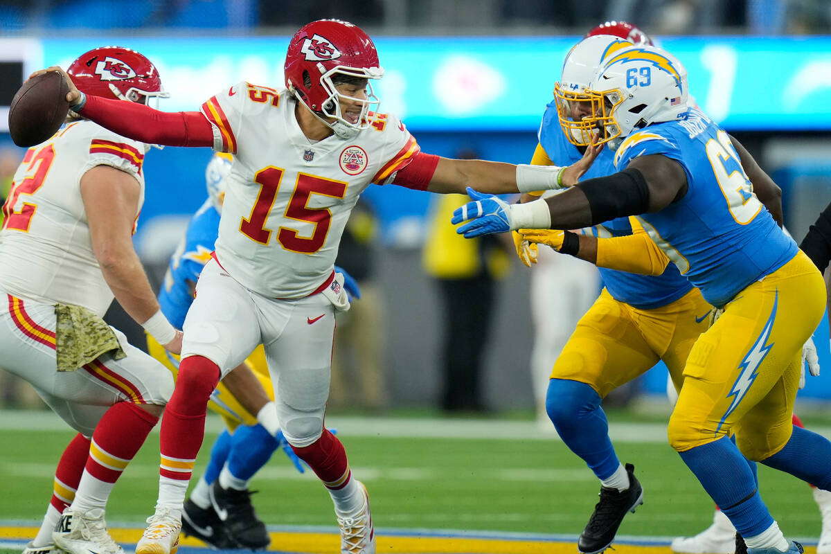 Kansas City Chiefs quarterback Patrick Mahomes, fends off Los Angeles Chargers defensive tackle ...