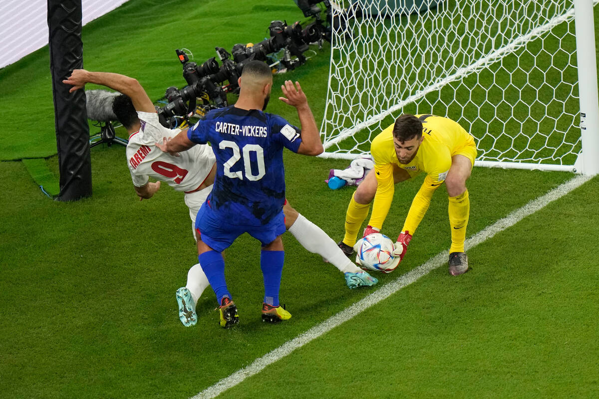 Iran's Mehdi Taremi fights for the ball against goalkeeper Matt Turner of the United States and ...