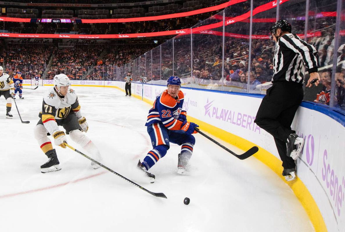 Vegas Golden Knights' William Karlsson (71) and Edmonton Oilers' Tyson Barrie (22) battle for t ...