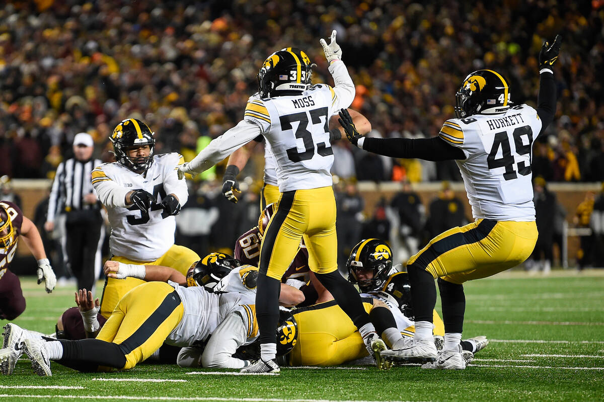 Iowa defensive lineman Yahya Black (94), defensive back Riley Moss (33) and defensive lineman E ...