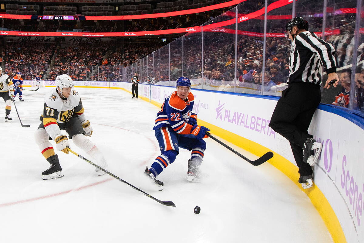 Vegas Golden Knights' William Karlsson (71) and Edmonton Oilers' Tyson Barrie (22) battle for t ...