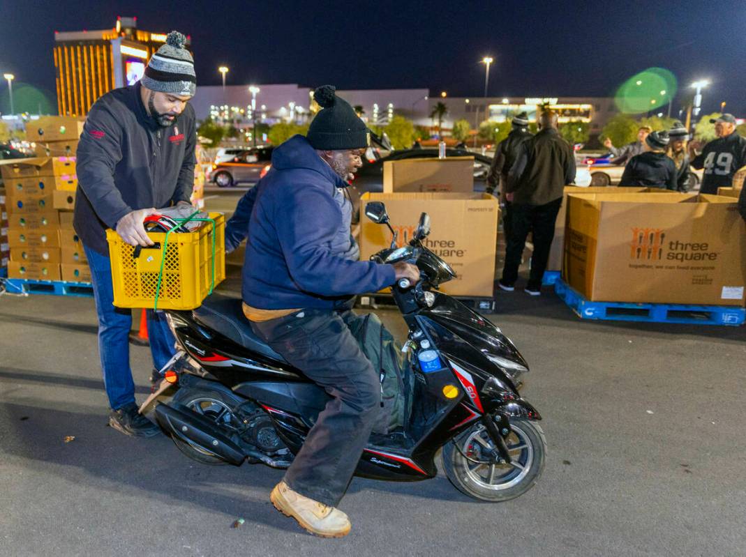 Former Raiders TE Teyo Johnson (82) secures a load of food given to Terrence Hazel as Raiders' ...